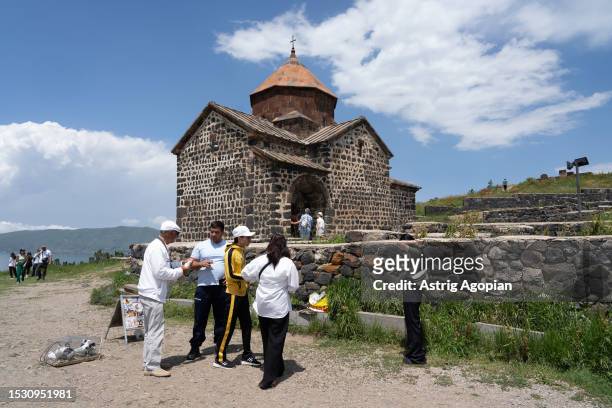 Tourists come to visit the Sevanavank monastery, which used to be on an island and now is on a peninsula as water decreased, overseeing Lake Sevan,...