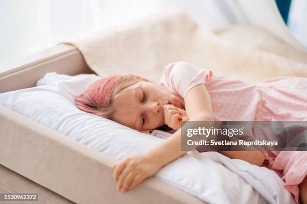 child biting his nails lying on the bed - nail biting stock pictures, royalty-free photos & images