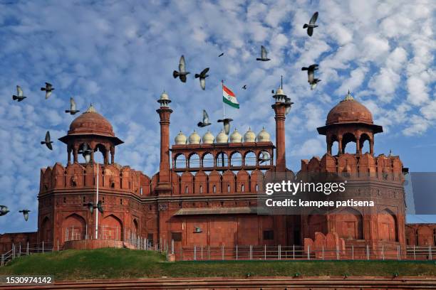 india's national pride: indian flag soaring above delhi's red fort - indian flag stock pictures, royalty-free photos & images