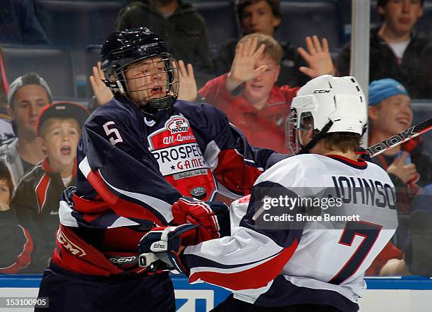 Mike Downing of Team Housley hits Luke Johnson of Team McClanahan at the USA Hockey All-American Prospects Game at the First Niagara Center on...