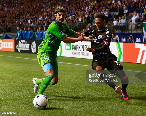 Jeff Parke of the Seattle Sounders FC and Matt Watson of the Vancouver Whitecaps FC race towards the ball during their MLS game September 29, 2012 at...