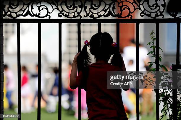 China-population-social-family,FEATURE BY CAROL HUANG This picture taken on September 19, 2012 shows a girl looking through in Beijing. China's...