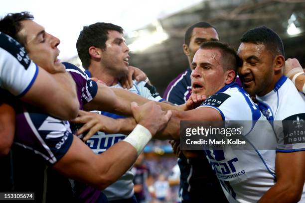 Josh Reynolds of the Bulldogs fends off Billy Slater of the Storm during the 2012 NRL Grand Final match between the Melbourne Storm and the...