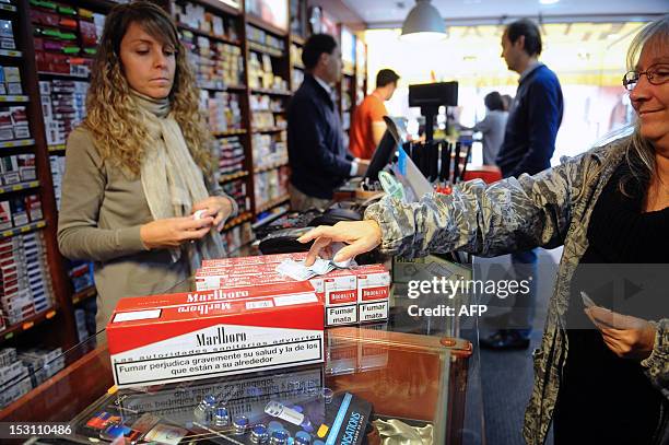 Woman buys cartons of cigarettes at a tobacconist's shop in the Spanish city of Les, located at the French-Spanish border on september 30, 2012. The...