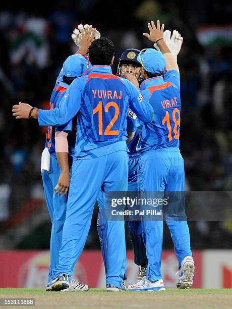 Yuvraj Singh of India celebrates the wicket of Nasir Jamshed of Pakistan with teammates Virat Kholi, captain M S Dhoni and Suresh Raina during the...