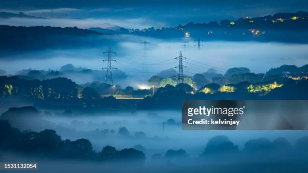 misty valley at night, showing electricity pylons - electricity pylon 個照片及圖片檔