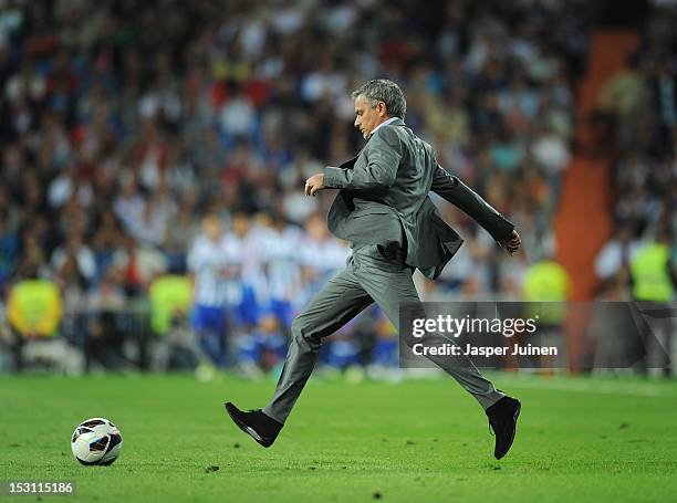 Head coach Jose Mourinho of Real Madrid kicks the ball on the pitch back to his players to resume the game after conceding an early opening goal...