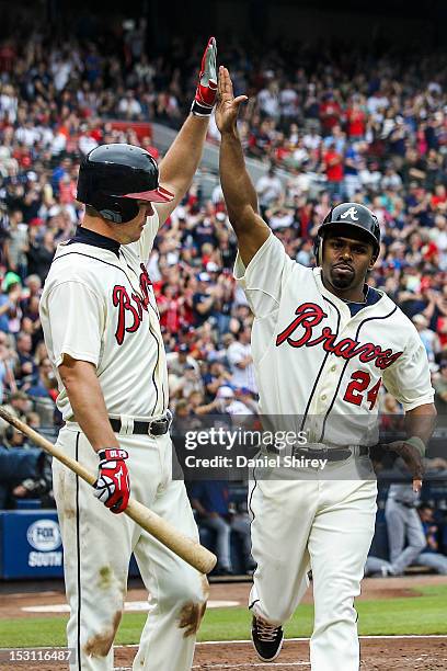 Michael Bourn celebrates with Chipper Jones of the Atlanta Braves after scoring in the fifth inning against the New York Mets at Turner Field on...
