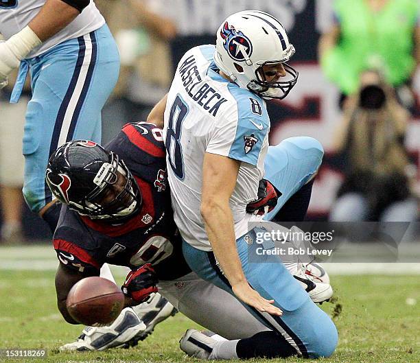 Antonio Smith of the Houston Texans forces Matt Hasselbeck of the Tennessee Titans to fumble the ball in the fourth quarter at Reliant Arena at...