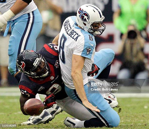 Antonio Smith of the Houston Texans forces Matt Hasselbeck of the Tennessee Titans to fumble the ball in the fourth quarter at Reliant Arena at...