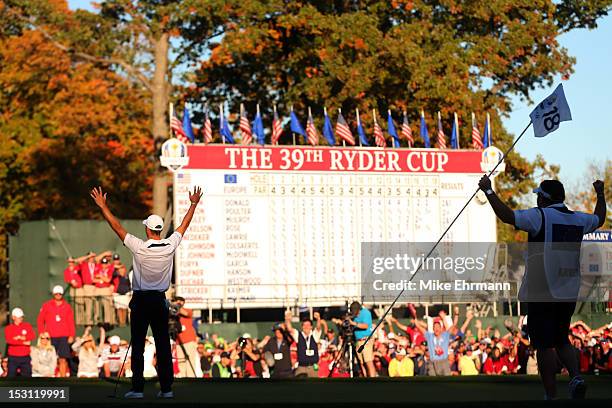 Martin Kaymer of Europe celebrates after making the winning putt as his caddie Craig Connelly watches on the 18th green to win The 39th Ryder Cup at...