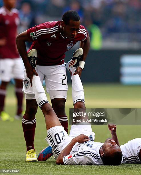 Hunter Freeman of the Colorado Rapids helps Dane Richards of the Vancouver Whitecaps FC regain his breath after a collision during their MLS game...