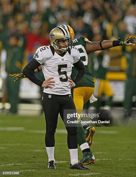 Garrett Hartley of the New Orleans Saints reacts after missing a field goal late in a game as Jerel Worthy of the Green Bay Packers runs past him in...