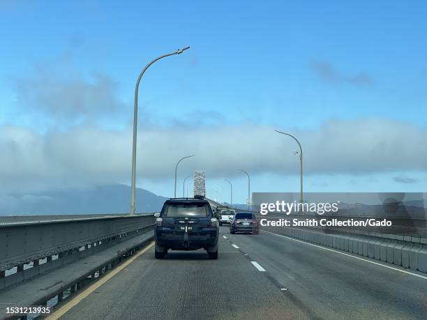 Car cruising under a clear sky and near a street light on the Richmond-San Rafael Bridge, with visible speed limit sign in San Quentin, California,...