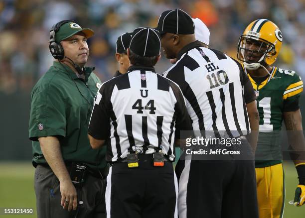 Green Bay Packers head coach Mike McCarthy argues a fumble call with umpire Jeff Rice and head linesman Phil McKinnely during a stopage of play...
