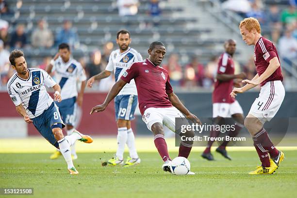 Omar Cummings of Colorado Rapids passes the ball to teammate Jeff Larentowicz during their MLS match against Los Angeles Galaxy at Dick's Sporting...