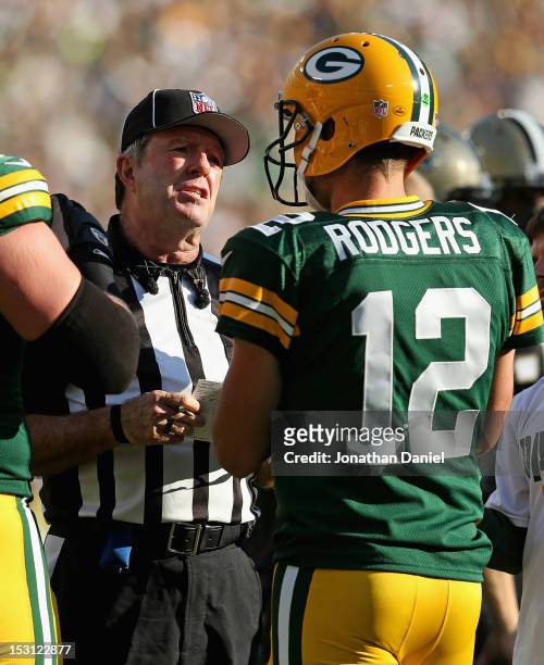 Umpire Jeff Rice talks with Aaron Rodgers of the Green Bay Packers during a break in the action against the New Orleans Saints at Lambeau Field on...