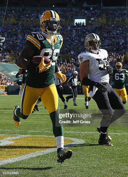 Wide receiver James Jones of the Green Bay Packers carries the ball into the endzone for a touchdown in front of outside linebacker Scott Shanle of...