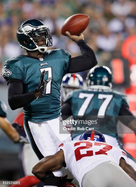 Quarterback Michael Vick of the Philadelphia Eagles throws a pass whlie being pressured by defensive back Stevie Brown of the New York Giants during...