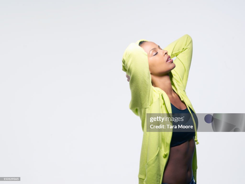 Sports woman with hands behind head looking happy