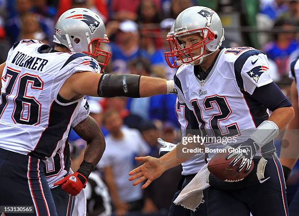 New England Patriots quarterback Tom Brady gets a hand from New England Patriots tackle Sebastian Vollmer after Brady scrambled for a 4-yard...