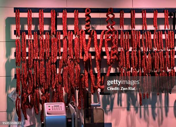sausages hang for sale in an indoor market in germany - insaccato foto e immagini stock
