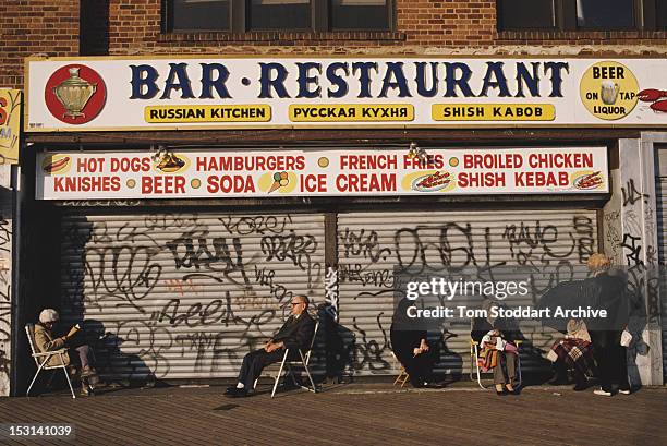 Elderly Russians sitting on deckchairs outside a Russian restaurant in 'Little Russia', Brighton Beach, Brooklyn, New York City, 1989.