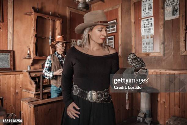 handsome black cowboy and beautiful blonde cowgirl in an authentic wild west setting with an owl - birds of prey stock pictures, royalty-free photos & images