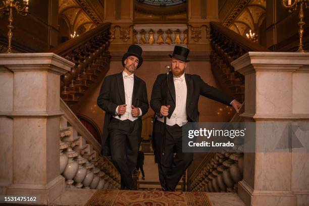 two handsome 1920s style gentlemen on a luxury stately home staircase - white tie event stock pictures, royalty-free photos & images