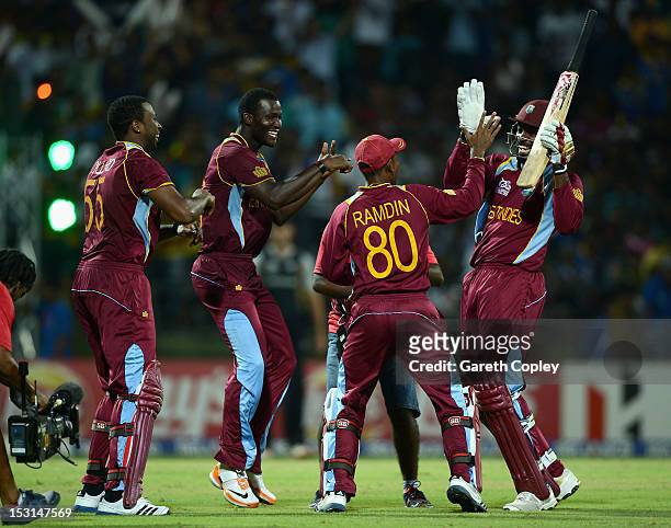 Chris Gayle of the West Indies celebrates with Kieron Pollard, Darren Sammy and Danesh Ramdin after winning the superover to win the ICC World...