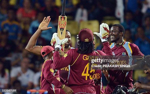 West Indies cricketer Chris Gayle celebrates his teams victory with teammates during the ICC Twenty20 Cricket World Cup Super Eight match between New...