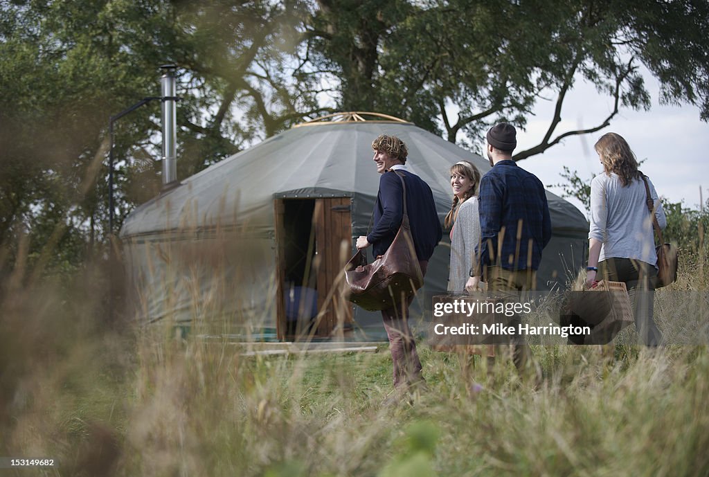 Glamping young people walking towards yurt.