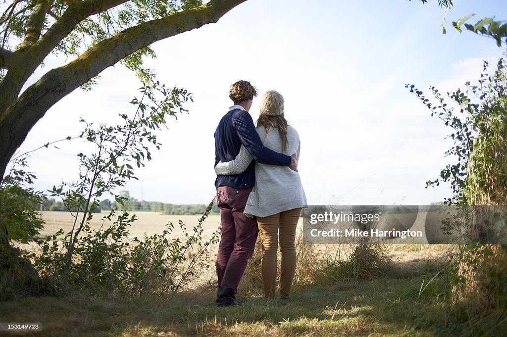 Couple embracing in countryside location.