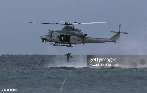 Philippine marines jumps off from a US marines UH-1Y Venom helicopter during a helocast and maritime patrol training exercise as part of the...