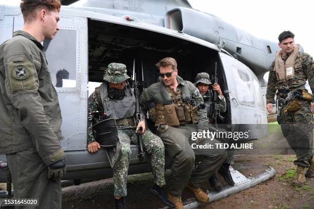 Marines gives instructions to their Philippine counterpart prior to dropping off from a UH-1Y Venom helicopter in a helocast and maritime patrol...