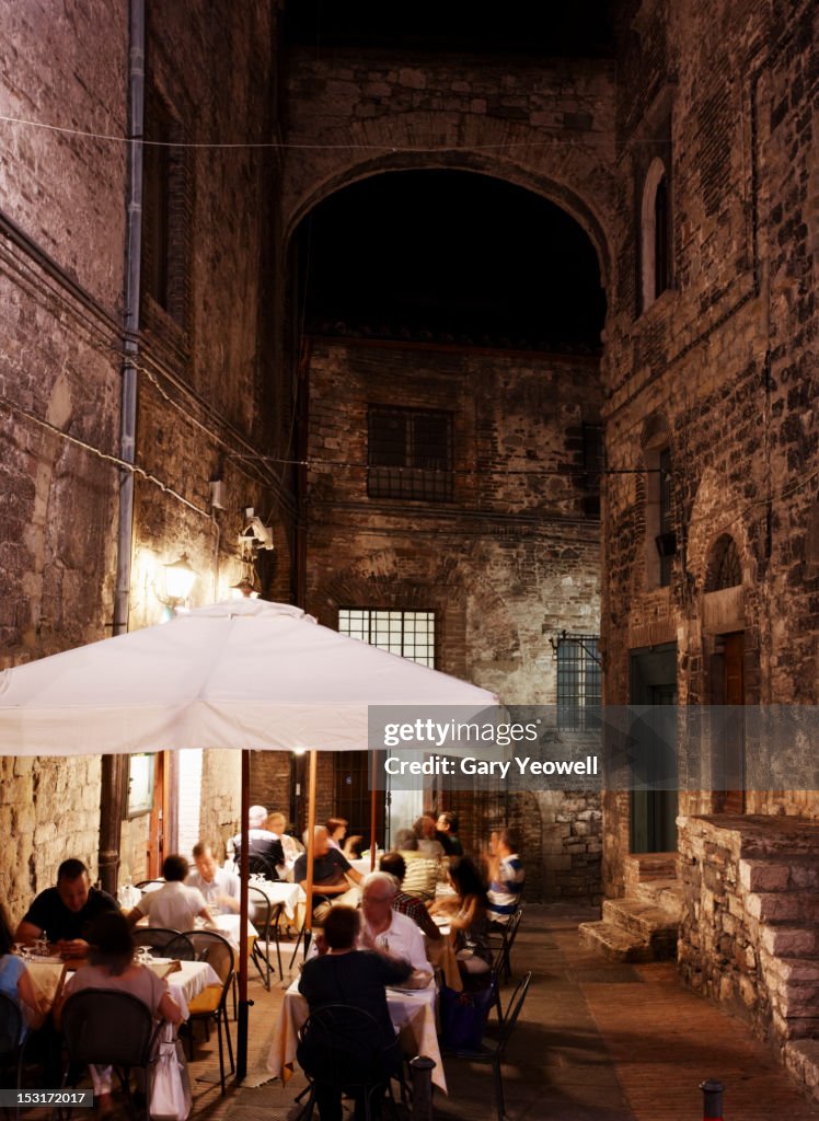 People dining outside restaurants at night