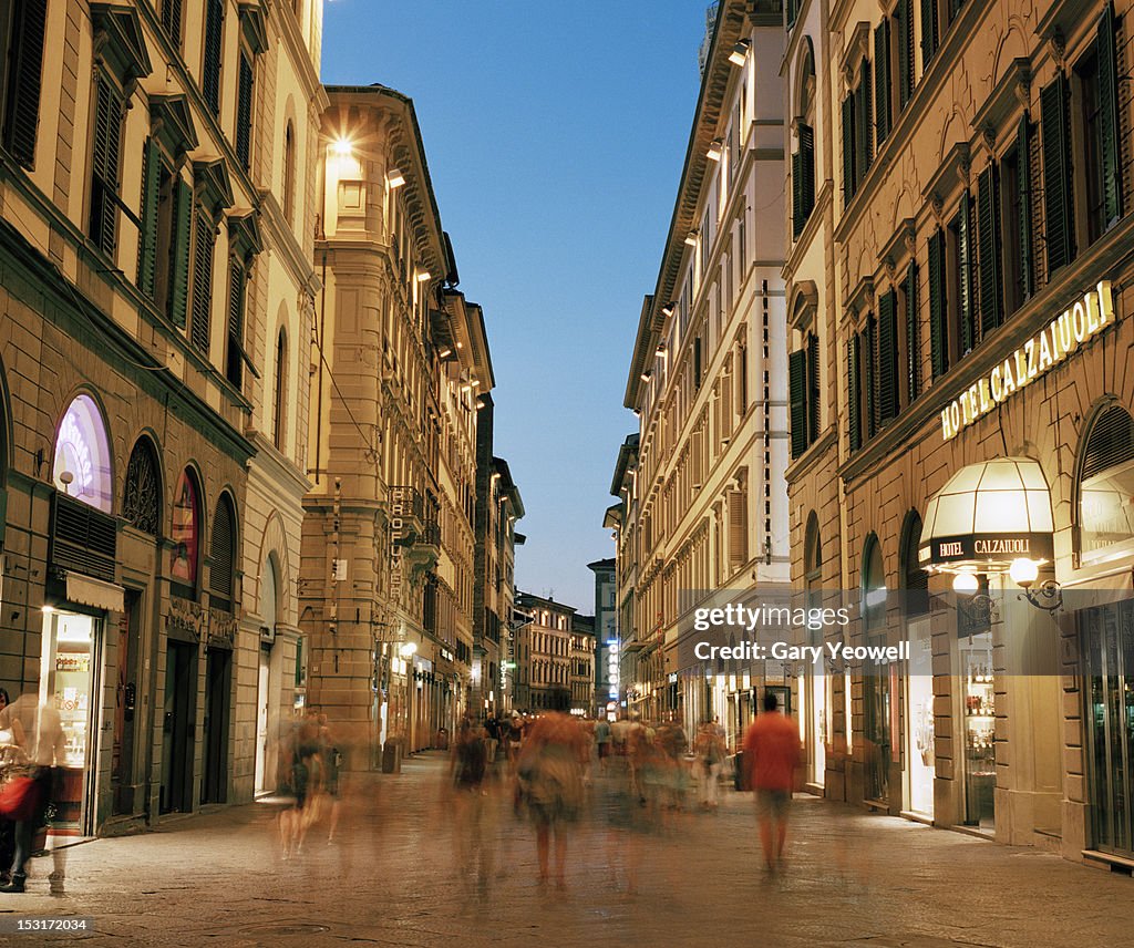 People walking along busy street at dusk