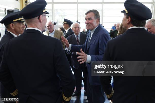 Sen. Mark Warner talks to pilots from United Airlines as Sen. Tim Kaine and Sen. Ben Cardin look on after a news conference at Ronald Reagan...