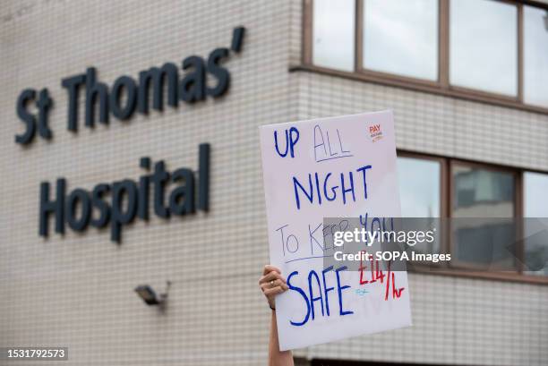 Protester holds a placard that reads 'UP ALL NIGHT TO KEEP YOU SAFE' during the demonstration. Junior doctors have been seen on strike in front of...