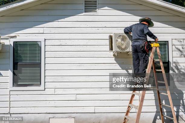 Tech Romero repairs an air conditioning unit on July 10, 2023 in Austin, Texas. Record-breaking temperatures continue soaring as prolonged heatwaves...