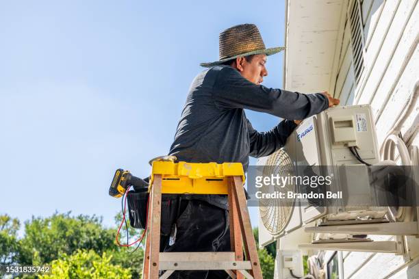 Tech Romero repairs an air conditioning unit on July 10, 2023 in Austin, Texas. Record-breaking temperatures continue soaring as prolonged heatwaves...