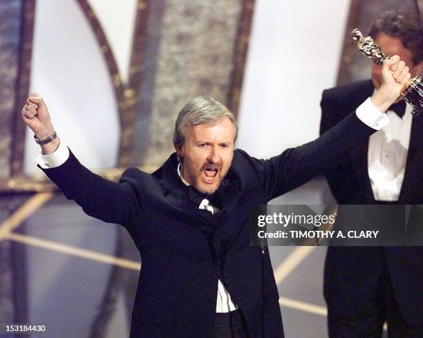 Director James Cameron raises his Oscar after winning in the Best Director Category during the 70th Academy Awards at Shrine Auditorium 23 March....