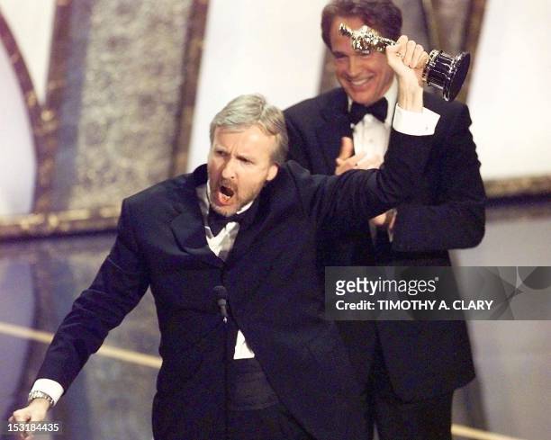 Director James Cameron raises his Oscar after winning in the Best Director Category during the 70th Academy Awards at Shrine Auditorium 23 March....