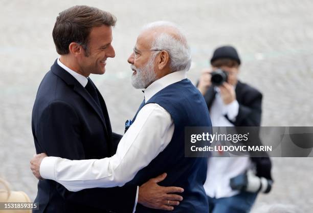 French President Emmanuel Macron greets India's Prime Minister Narendra Modi during the Bastille Day military parade on the Champs-Elysees avenue in...