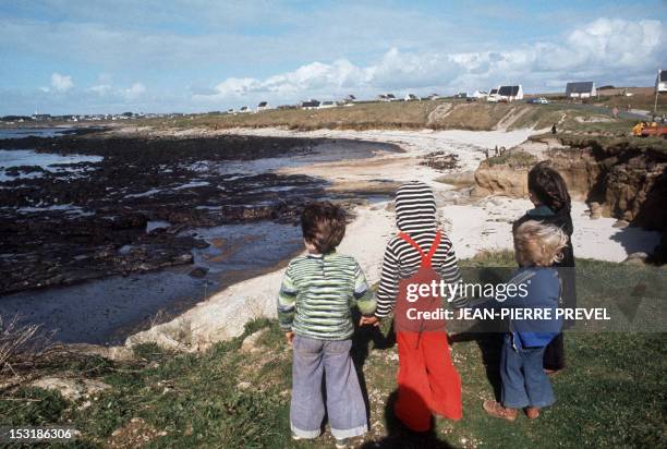 Children look at a beach, covered with oil, on April 12 after the sinking of the oil tanker Amoco Cadiz, near the small port of Portsall, on the...