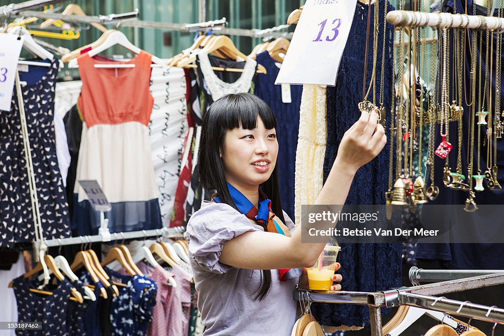 Asian woman shopping at marketstall.