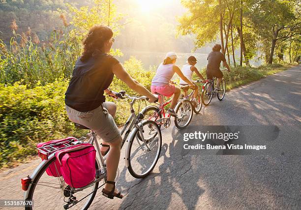 family on bicycle on a country road - family bicycle stock pictures, royalty-free photos & images