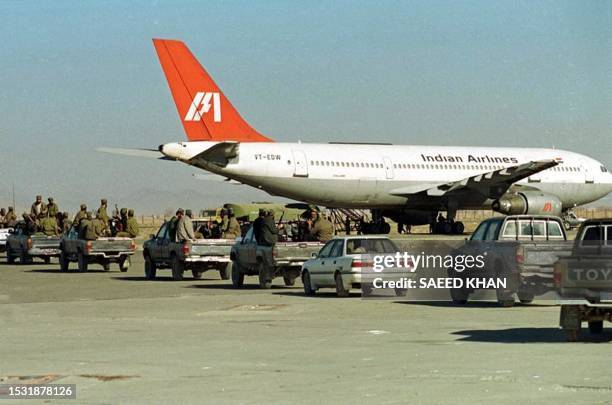 Taliban Islamic militia commandos in pick-up trucks rush towards the Indian hijacked plane at Kandahar airport in Afghanistan, 30 December 1999....