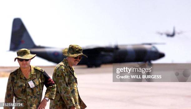 Air force police leave the tarmac after watching a British Hercules aircraft take off from Darwin's Royal Australian Airforce base , September 18...