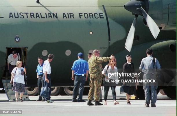 United Nations personnel and Australian leave an Australian Air Force's hercules aircraft 06 September 1999 upon their arrival in Darwin after being...